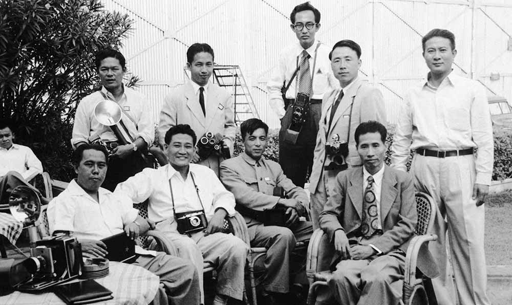 新華社記者錢嗣杰（站立者右二）在采訪會(huì)議開幕式后和外國記者在會(huì)場(chǎng)外休息。