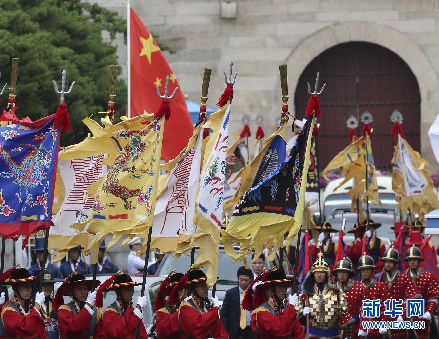 7月3日，韓國(guó)總統(tǒng)樸槿惠在青瓦臺(tái)總統(tǒng)府舉行隆重儀式，歡迎中國(guó)國(guó)家主席習(xí)近平對(duì)韓國(guó)進(jìn)行國(guó)事訪問(wèn)。這是習(xí)近平的車隊(duì)在身著民族服裝的韓國(guó)禮儀隊(duì)伍引導(dǎo)下駛?cè)肭嗤吲_(tái)。新華社記者丁林?jǐn)z  